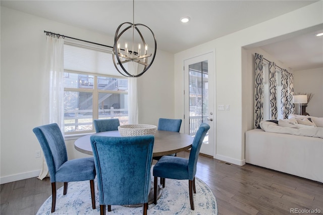 dining space featuring an inviting chandelier, wood finished floors, visible vents, and baseboards