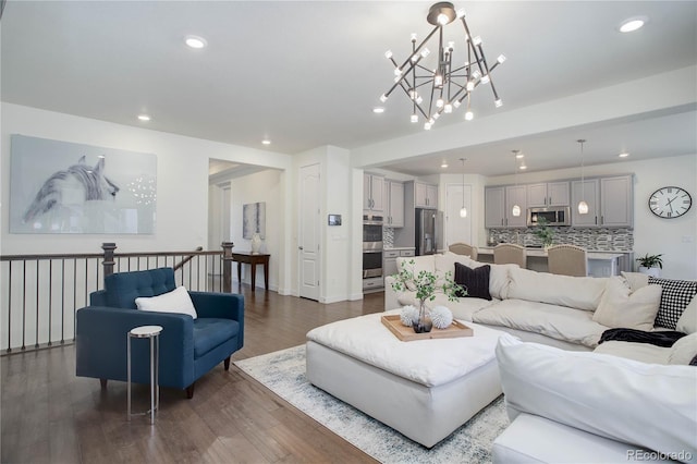 living area with recessed lighting, baseboards, an inviting chandelier, and wood finished floors