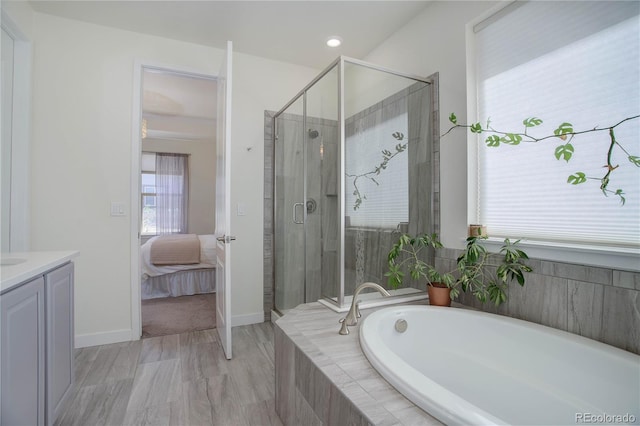 full bathroom featuring vanity, baseboards, a shower stall, ensuite bathroom, and a bath