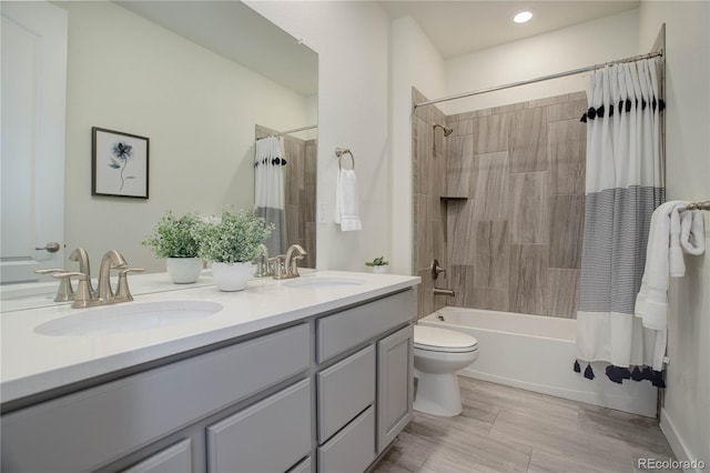 full bath with a sink, shower / bath combo with shower curtain, toilet, and double vanity