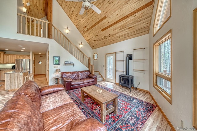 988 Ruby Ln, Leadville, CO 80461 - living room featuring stairs, a wood stove, high vaulted ceiling, light wood-style flooring, and ceiling fan