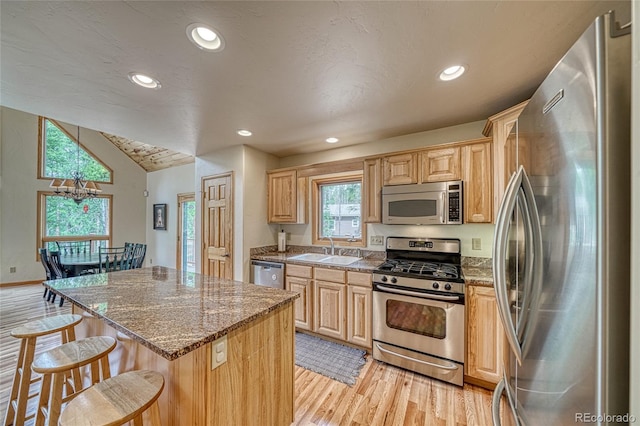 988 Ruby Ln, Leadville, CO 80461 - kitchen with stainless steel appliances, a kitchen breakfast bar, light wood-style floors, a center island, and light brown cabinetry