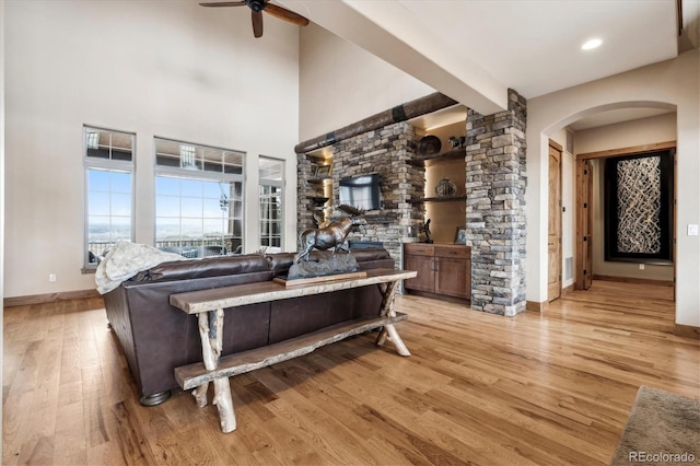 living room with beamed ceiling, ceiling fan, and light hardwood / wood-style floors