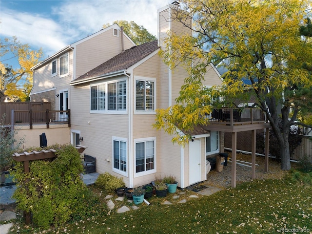 back of house featuring a wooden deck and a yard