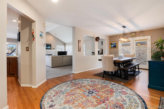 dining space with lofted ceiling, light hardwood / wood-style floors, and a wealth of natural light