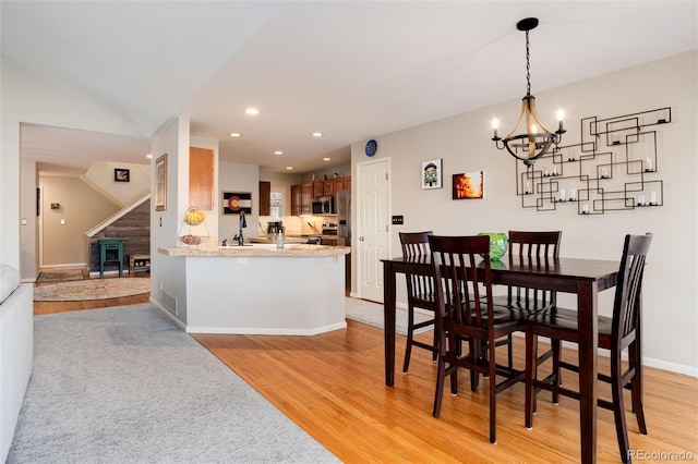 dining room with a notable chandelier and light wood-type flooring