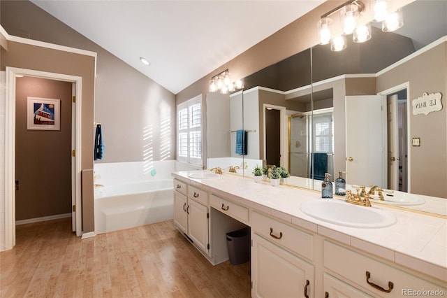 bathroom featuring hardwood / wood-style flooring, vanity, a notable chandelier, vaulted ceiling, and separate shower and tub