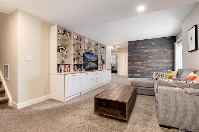 living room featuring wooden walls and carpet flooring