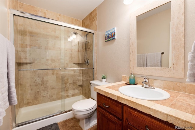 bathroom with vanity, toilet, and a shower with door