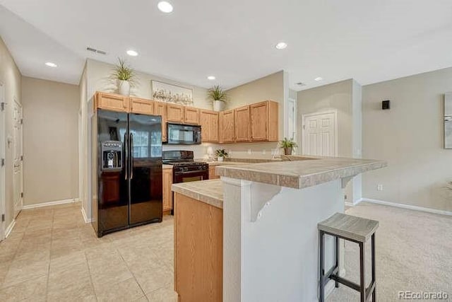 17225 Lark Water Ln Unit C, Parker, CO 80134 - kitchen featuring black appliances, a kitchen breakfast bar, a peninsula, light countertops, and recessed lighting