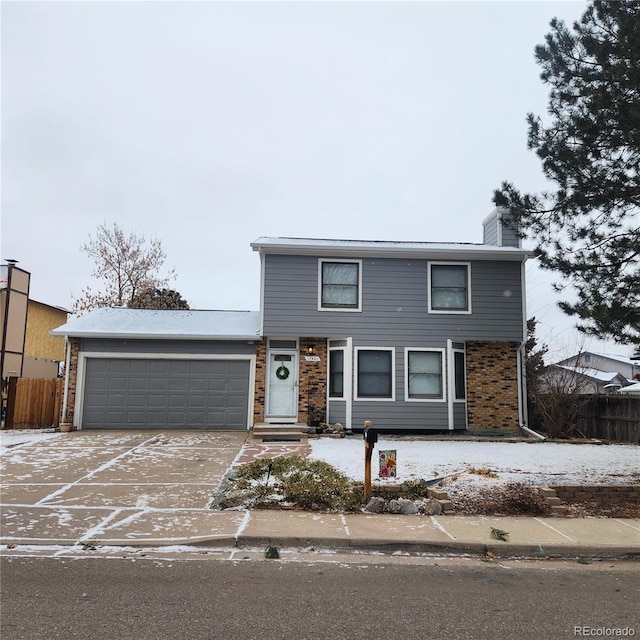 traditional home featuring concrete driveway, a chimney, an attached garage, and fence