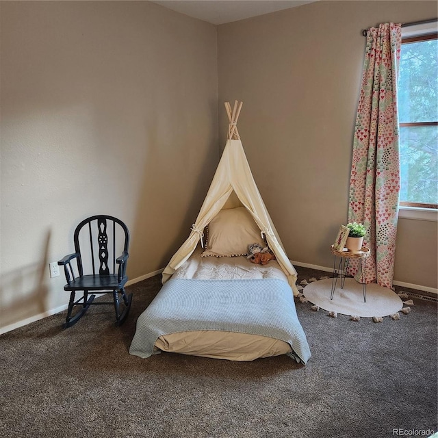 carpeted bedroom featuring multiple windows and baseboards