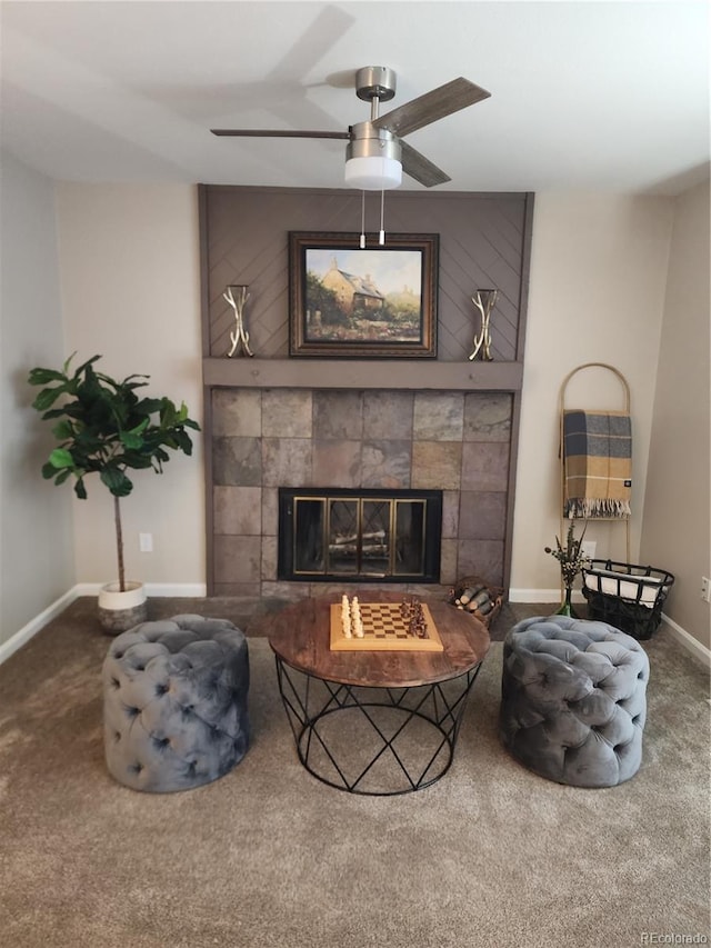 carpeted living room featuring a ceiling fan, baseboards, and a tiled fireplace