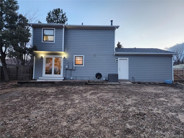 back of house featuring central AC unit and fence