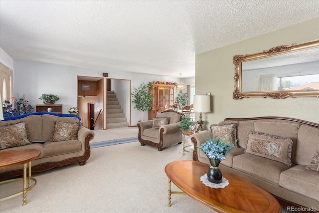 living room featuring carpet flooring, a textured ceiling, and stairway