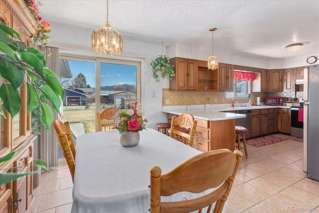 dining space with a textured ceiling, an inviting chandelier, and light tile patterned floors