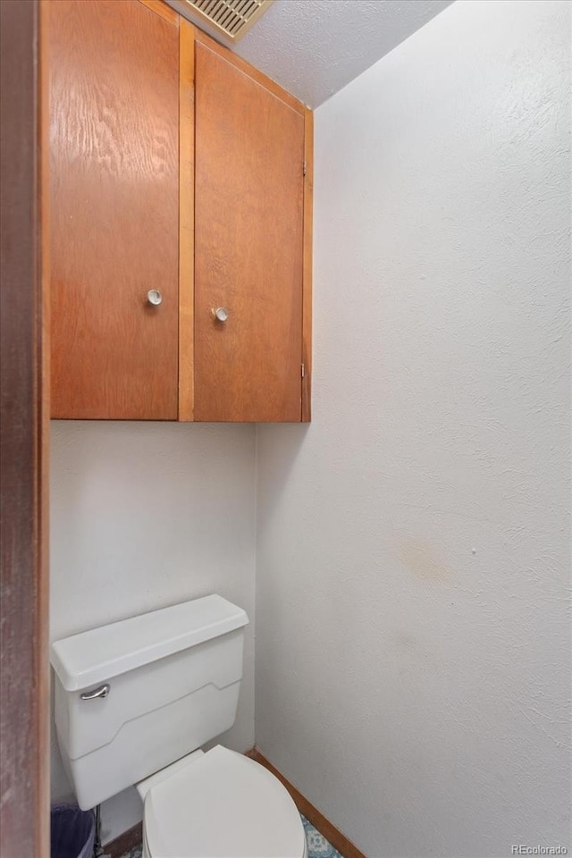 bathroom featuring visible vents and toilet