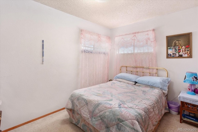 bedroom with baseboards, a textured ceiling, and carpet