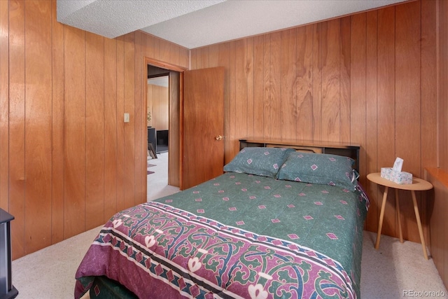 carpeted bedroom with a textured ceiling and wooden walls