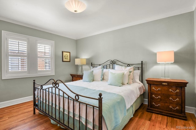 bedroom with crown molding and light hardwood / wood-style floors