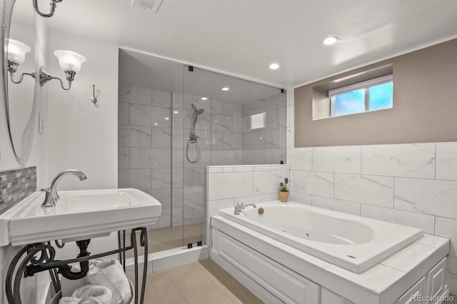 bathroom featuring independent shower and bath, sink, and tile patterned flooring