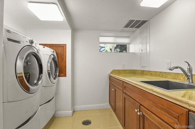 laundry room featuring sink, light tile patterned floors, washing machine and dryer, and cabinets