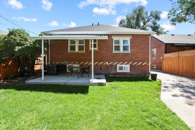 rear view of property with a patio, a yard, and central AC unit