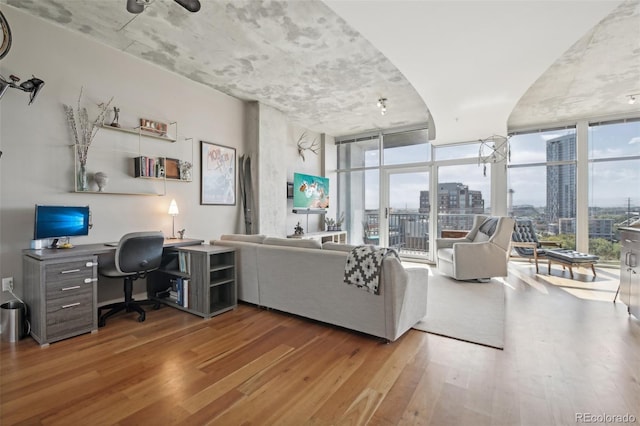 living room with wood-type flooring and a wall of windows