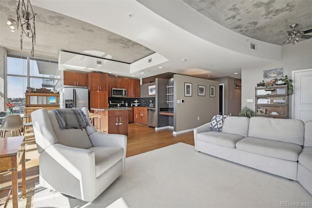 living room with ceiling fan and light hardwood / wood-style floors