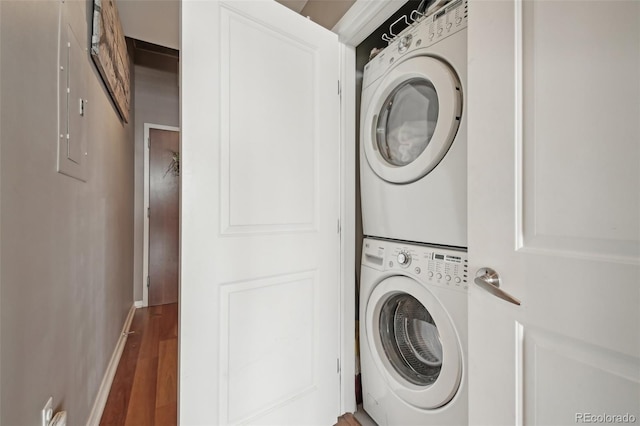 washroom featuring stacked washer and dryer and hardwood / wood-style flooring