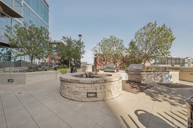 view of patio with a grill, a fire pit, and exterior kitchen