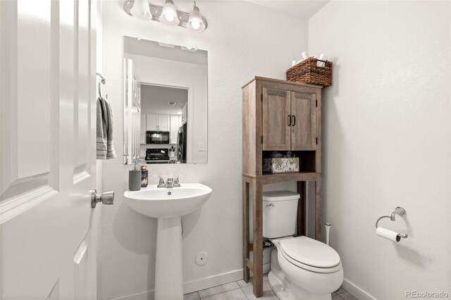 5744 Alton St, Denver, CO 80238 - half bathroom with toilet, tile patterned flooring, and baseboards