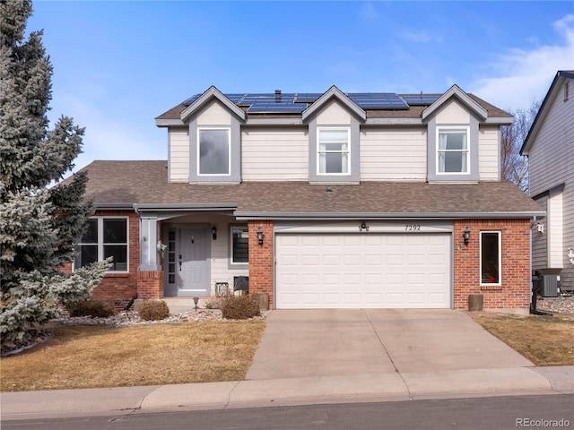 view of front of house with brick siding, driveway, an attached garage, and central AC unit