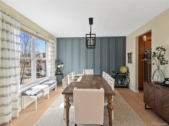 dining area featuring light wood finished floors and baseboards