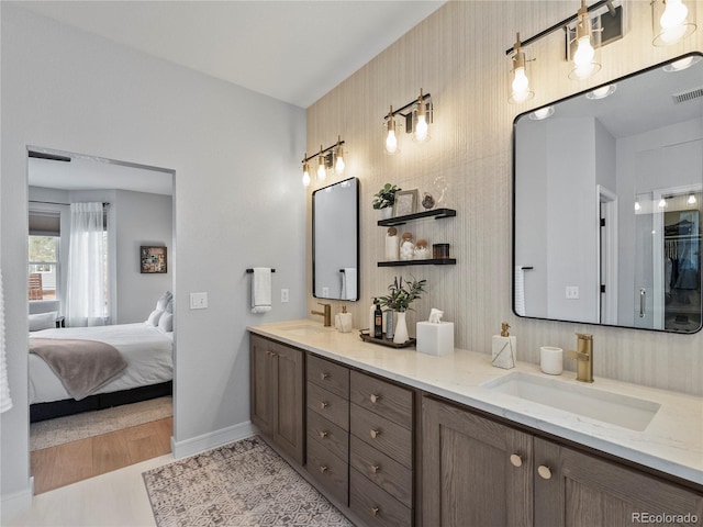 full bath with double vanity, baseboards, visible vents, and a sink