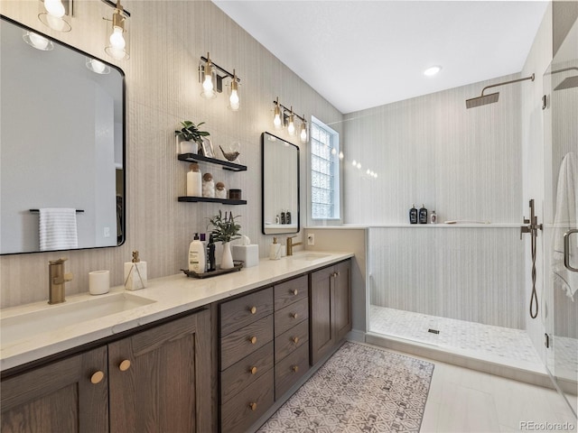 full bathroom featuring double vanity, tile patterned flooring, a sink, and a shower stall