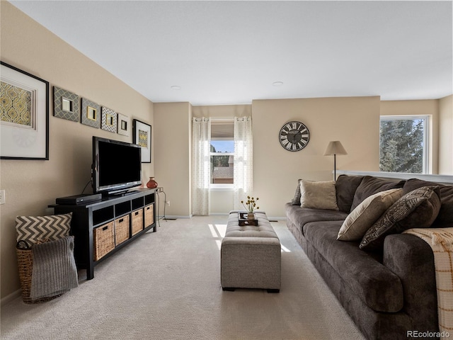 living room with a wealth of natural light, baseboards, and carpet flooring