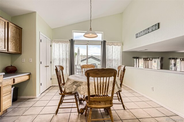 9882 Harris St, Thornton, CO 80229 - dining space featuring light tile patterned floors, built in desk, and high vaulted ceiling