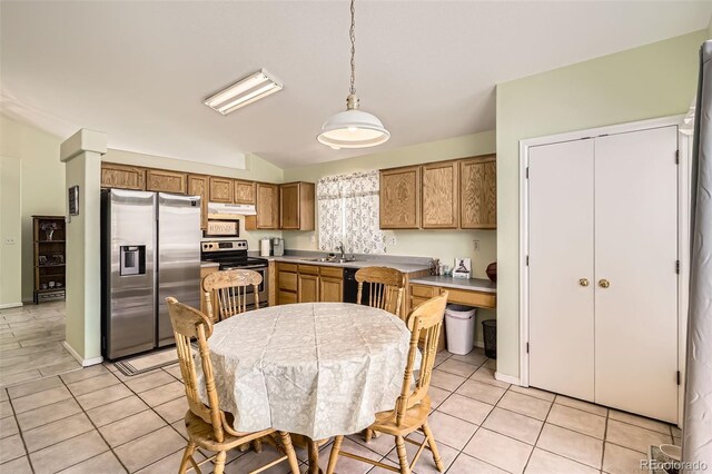 9882 Harris St, Thornton, CO 80229 - kitchen with stainless steel appliances, under cabinet range hood, lofted ceiling, light tile patterned floors, and pendant lighting