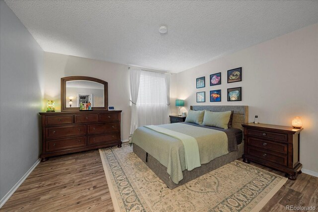 bedroom featuring wood-type flooring and a textured ceiling