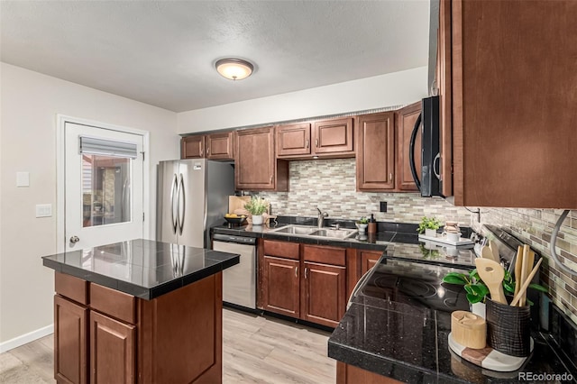 4784 S Tabor St, Morrison, CO 80465 - kitchen featuring appliances with stainless steel finishes, decorative backsplash, light wood-style floors, and a center island