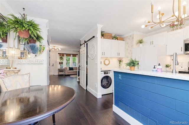 9620 W Chatfield Ave Unit D, Littleton, CO 80128 - kitchen featuring washer / clothes dryer, a chandelier, freestanding refrigerator, a barn door, and ornamental molding