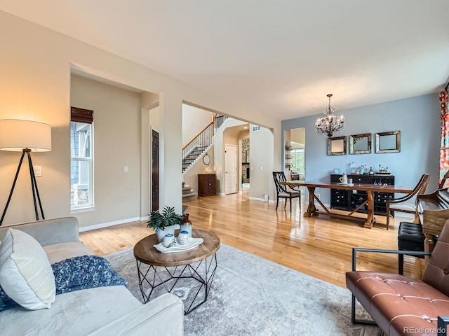 2896 Gemini Loop, Broomfield, CO 80023 - living area with a chandelier, stairs, light wood-style floors, and baseboards