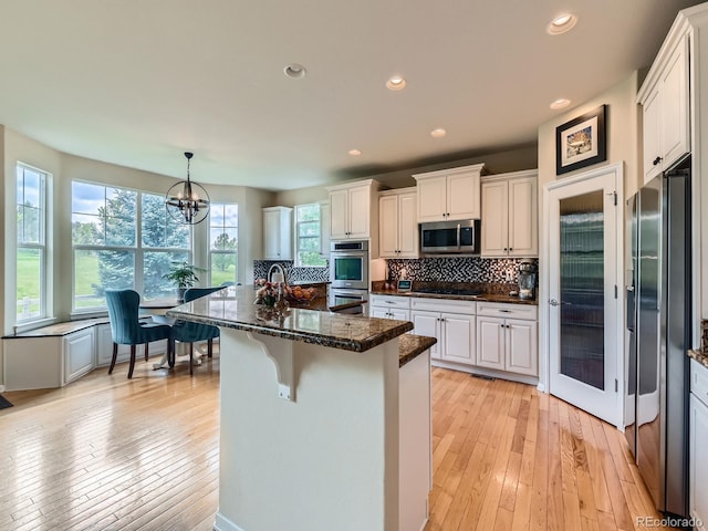 2896 Gemini Loop, Broomfield, CO 80023 - kitchen with stainless steel appliances, decorative backsplash, recessed lighting, light wood-style flooring, and white cabinetry