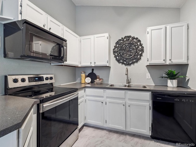 kitchen with black appliances, a sink, dark countertops, and white cabinets