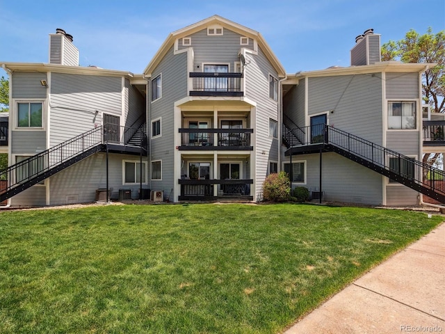 5690 W 80th Pl Unit 101, Arvada, CO 80003 - back of property with a chimney, stairs, and a lawn
