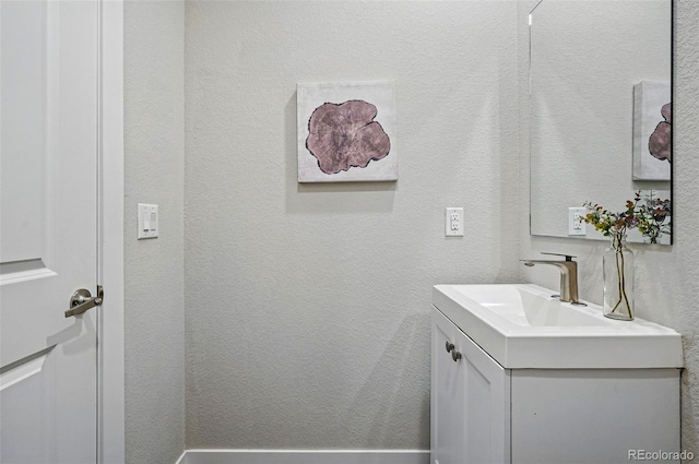 bathroom featuring a textured wall and vanity