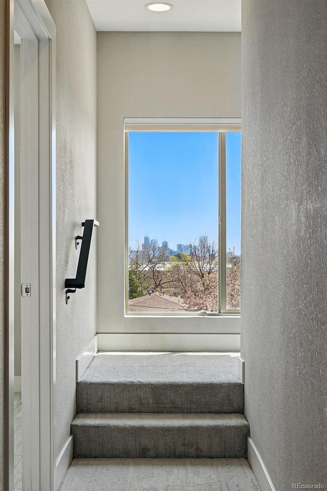 stairs featuring a textured wall and baseboards