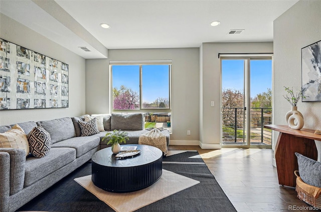 living room with visible vents, recessed lighting, dark wood finished floors, and baseboards