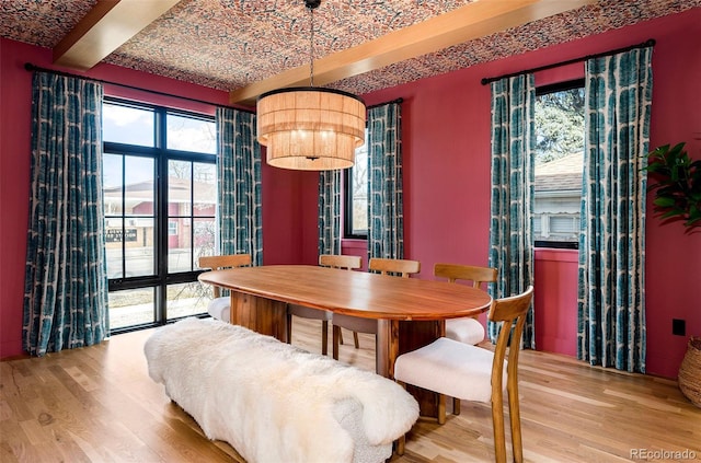 dining area with brick ceiling, a notable chandelier, beam ceiling, and wood finished floors